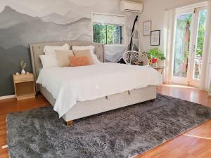 1 dormitorio con 1 cama grande y 1 alfombra en 11 chartwell en Brisbane