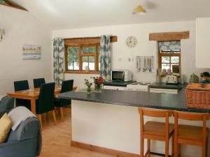 a kitchen with a counter top and a table and chairs at Oaktree Cottage in Appledore