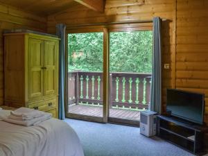 a bedroom with a bed and a balcony with a television at Red Kite Lodge - Uk37417 in Legbourne