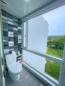 a bathroom with a toilet and a large window at 35.5 Inn in Kenting