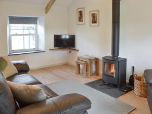 a living room with a couch and a wood stove at Number Nineteen in Lower Boscaswell