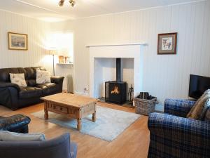 a living room with a couch and a fireplace at Seaforth Cottage in Cononbridge