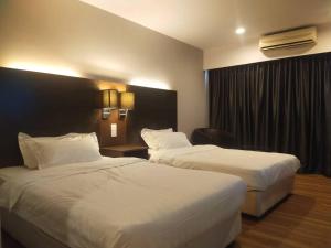 a hotel room with two beds and a window at Residence-South China Sea Place by WinJ Management in Kota Kinabalu