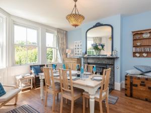 a dining room with a table and chairs and a mirror at Moonbeam House in Freshwater