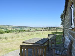 a table and two chairs on the porch of a house at The Byre in Westerdale