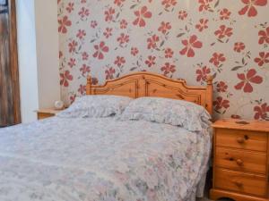 a bedroom with a bed and a wooden dresser at The Old Brewery in Builth Wells