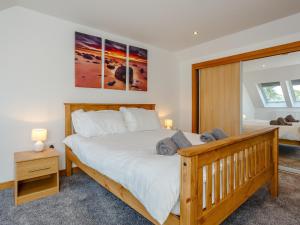 1 dormitorio con 1 cama grande con marco de madera en Auld Kirk Hall, en Kirktown of Auchterless