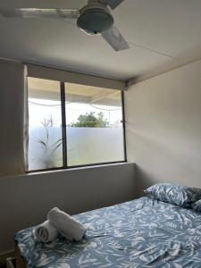 a bedroom with a bed with a pillow and a window at Adalong Student Guest House in Brisbane