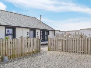 a wooden fence in front of a house at Captains Cottage in Allonby
