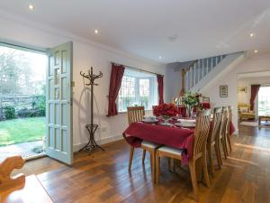 a dining room with a table and chairs and a staircase at Twisly North Lodge in Catsfield