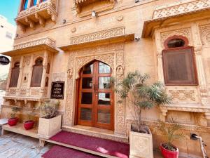 a building with a door and potted plants in front of it at Hotel Jaisan Haveli in Jaisalmer