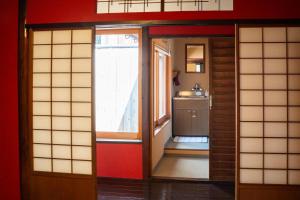 金澤的住宿－古都とき Kototoki，一间设有门的房间和一间带窗户的厨房
