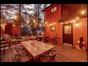 a wooden deck with a wooden table and chairs at Sugar in the Raw Cabin - Hot Tub in Sugarloaf