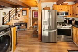 a kitchen with a stainless steel refrigerator and a staircase at Sugar in the Raw Cabin w AC - Hot Tub in Sugarloaf