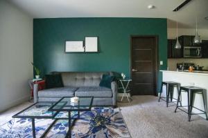 a living room with a couch and a green wall at Luxury 2BR/W King Suite in Las Vegas