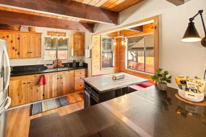 a kitchen with wooden cabinets and a black stove at Sugar in the Raw Cabin w AC - Hot Tub in Sugarloaf