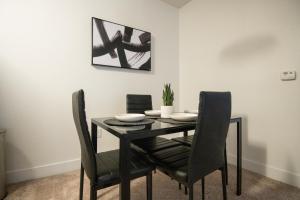 a black dining room table with black chairs and a picture at Luxury 2BR/W King Suite in Las Vegas