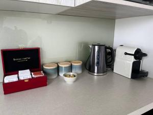 a kitchen counter with a coffee maker and a coffee pot at Views on Florence in Queenstown