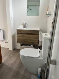uma casa de banho com um WC branco e um lavatório. em Views on Florence em Queenstown