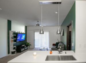 a kitchen with a sink and a living room at Luxury 2BR/W King Suite in Las Vegas