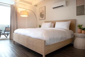 a bedroom with a large bed with white sheets at Hollywood Hills Hotel in Los Angeles