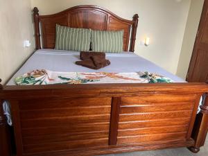 a large wooden bed with a wooden foot board at Terrapin village and hostel in Pwani Mchangani