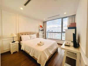 a bedroom with a bed with a teddy bear on it at DongDong Luxury Apartment in Vinhomes Central Park in Ho Chi Minh City