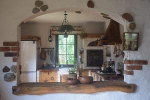 a kitchen with a table and a refrigerator and a window at Chatka skrzatka in Kruki