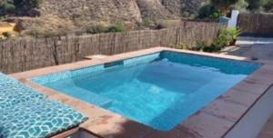 a swimming pool in a backyard with a fence at A tranquil mountain escape, casa particular, exclusive accommodation, private pool and terraces in Oria