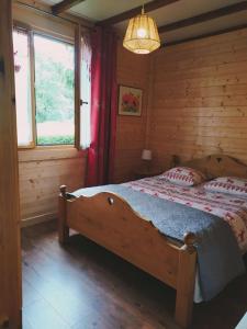 een slaapkamer met een bed in een blokhut bij Chalet du Spièmont in Champdray