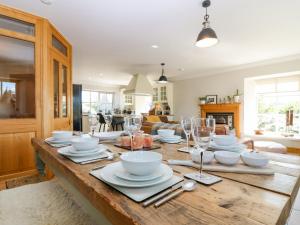 a wooden table with plates and glasses on top of it at Stable Cottage in Inverurie