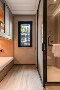 a bathroom with a shower and a glass door at Zunjing Boutique Hotel Nanjing Confucius Temple in Nanjing