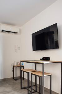 a room with a table and a tv on a wall at Kiriakos Apartment in Kalamata