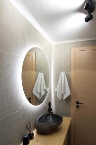 a bathroom with a stone sink and a mirror at Kiriakos Apartment in Kalamata