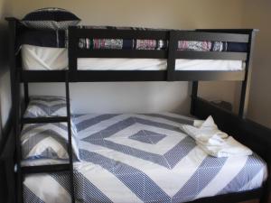 a bunk bed with ties on the bottom bunk at RIVER DOWNS COTTAGE in Clarence Town
