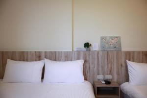 um quarto com 2 camas com almofadas brancas e uma cabeceira em madeira em Between mountains B&B em Jian