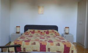 a bedroom with a bed with a quilt on it at Jovanoski Apartments in Struga