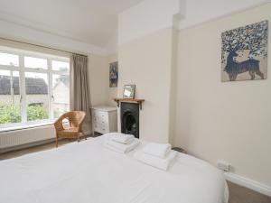 Dormitorio blanco con cama y chimenea en 2 Church Street, en Chipping Norton