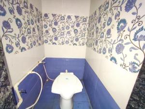 y baño con aseo y papel pintado de color azul y blanco. en SARDAR HOME STAY, en Garudeshwar