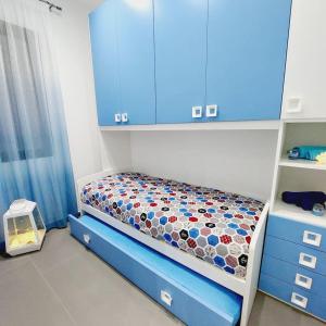 - une petite chambre avec un lit et des armoires bleues dans l'établissement Casa vacanze Sicilia bedda partinico, à Partinico