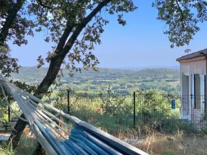 una hamaca a la sombra de un árbol con vista en Provencal villa with stunning view & summer pool, en Rochefort-du-Gard