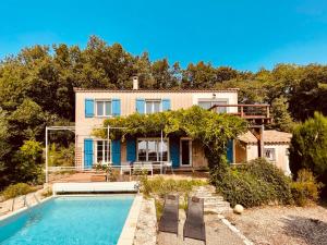 une maison avec une piscine en face d'une maison dans l'établissement Provencal villa with stunning view & summer pool, à Rochefort-du-Gard