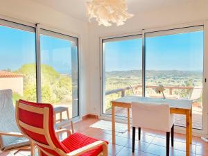 - une salle à manger avec une table, des chaises et de grandes fenêtres dans l'établissement Provencal villa with stunning view & summer pool, à Rochefort-du-Gard