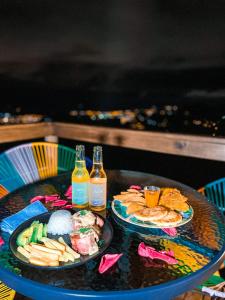 Glamping Itawa & Ecoparque turístico في فيلافيسينسيو: طاولة مع طبقين من الطعام وزجاجتين من البيرة
