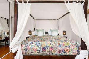 um quarto com uma cama de dossel e cortinas brancas em Classical King Bed Home @ Edge hill; 5km to Cairns em Edge Hill