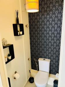 uma casa de banho com WC e papel de parede preto e branco em Appartement cocooning em Villetaneuse