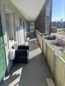 - une terrasse couverte avec des chaises et des fleurs dans un bâtiment dans l'établissement Glöm dina bekymmer i denna rymliga lägenhet, à Trollhättan