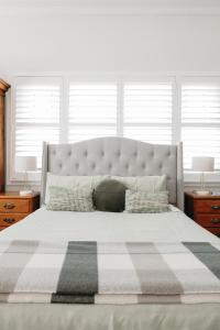 um quarto com uma cama grande e um cobertor xadrez em The Westbury Dubbo em Dubbo