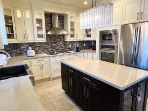 a kitchen with white cabinets and a stainless steel refrigerator at Jennifer's House in Vancouver