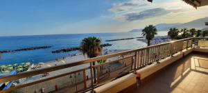 a view of a beach with palm trees and the ocean at Casa Anna appartamento fronte mare Ventimiglia in Ventimiglia